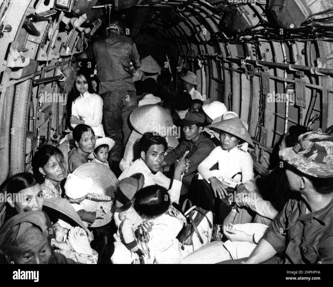 Sbalordito dalla vivacità di un attacco Viet Cong al loro villaggio, i rifugiati della guerra del Vietnam cavalcano un elicottero dell'Aeronautica militare in un'area sicura vicino Saigon. Marzo 1966. CA. Marzo 1966 Foto Stock