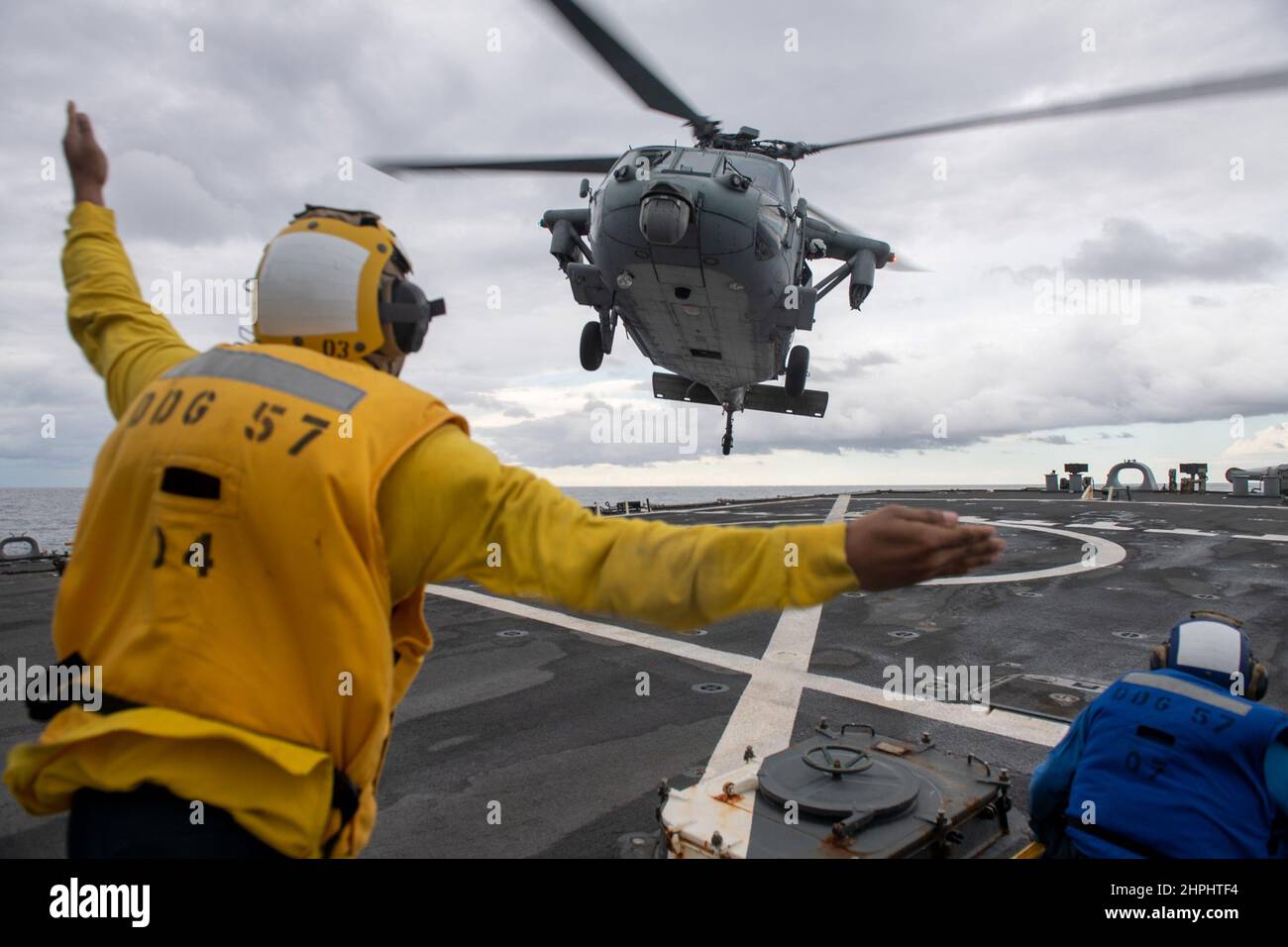 220216-N-HG846-1073 MARE ADRIATICO (16 febbraio 2022) Boatswain’s Mate 3rd Classe traa’shaun Cooper, di Homestead, Texas, dirige un elicottero MH-60s Sea Hawk assegnato ai “Dragon Slayers” dello Squadrone da combattimento con elicottero marino (HSC-11) per atterrare a bordo del cacciatorpediniere missilistico guidato di classe Arleigh Burke USS Mitscher, DG 57, 2022 febbraio 16, DG. Mitscher è schierato con il gruppo di colpo della portante di Harry S. Truman su un dispiegamento programmato nell'area della sesta flotta degli Stati Uniti delle operazioni di sostegno alle operazioni navali per mantenere la stabilità e la sicurezza marittima e difendere gli interessi degli Stati Uniti, alleati e partner in Europa e AF Foto Stock