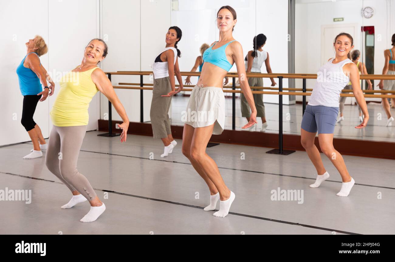 Gruppo di donne attive che praticano la danza energetica in uno studio Foto Stock Gruppo di donne attive che praticano la danza energetica in uno studio Foto Stock