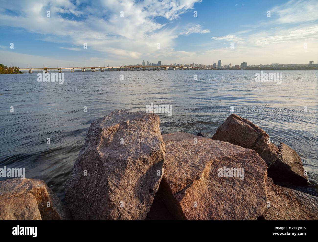 Dnepropetrovsk, panorama della città, centro e ponte centrale sulle rive del Dnieper, pietre di granito in primo piano Foto Stock