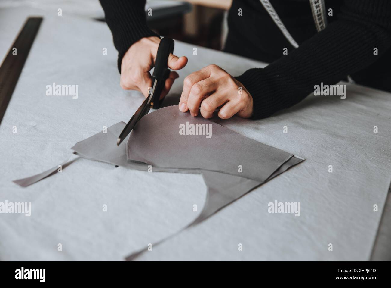 Design su misura per il taglio di un pezzo di stoffa con forbici, concetto imprenditore. Foto Stock