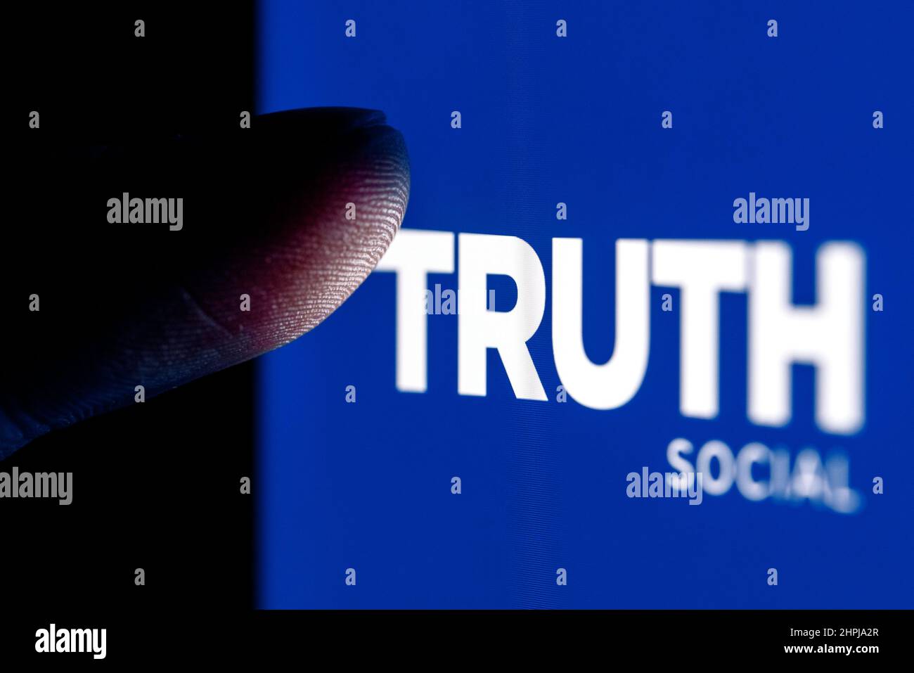 Il dito raggiunge il logo Truth Social Network sullo schermo dello smartphone. Foto Stock