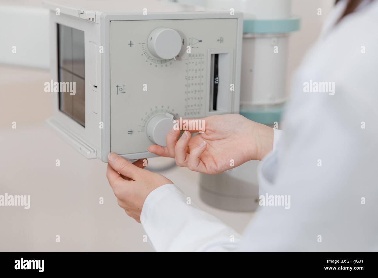 Sala di radiologia ospedaliera. Macchina a raggi X per fluorografia. Radiologo medico in abito regolazione della macchina a raggi X per la radiografia. Apparecchiature mediche Foto Stock