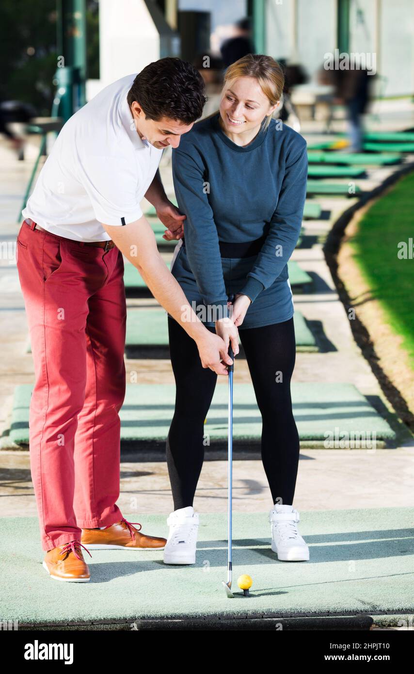L'addestratore di golf insegna un gioco della donna Foto Stock