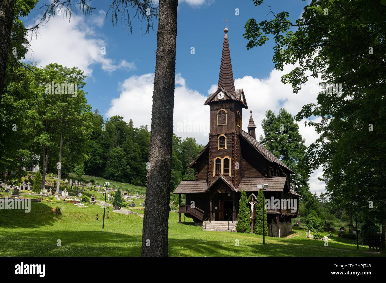 Chiesa di legno di Sant'Anna in Tatranska Javorina, una piccola città in NP Belianske Tatry, con un cimitero e alberi, Slovacchia Foto Stock