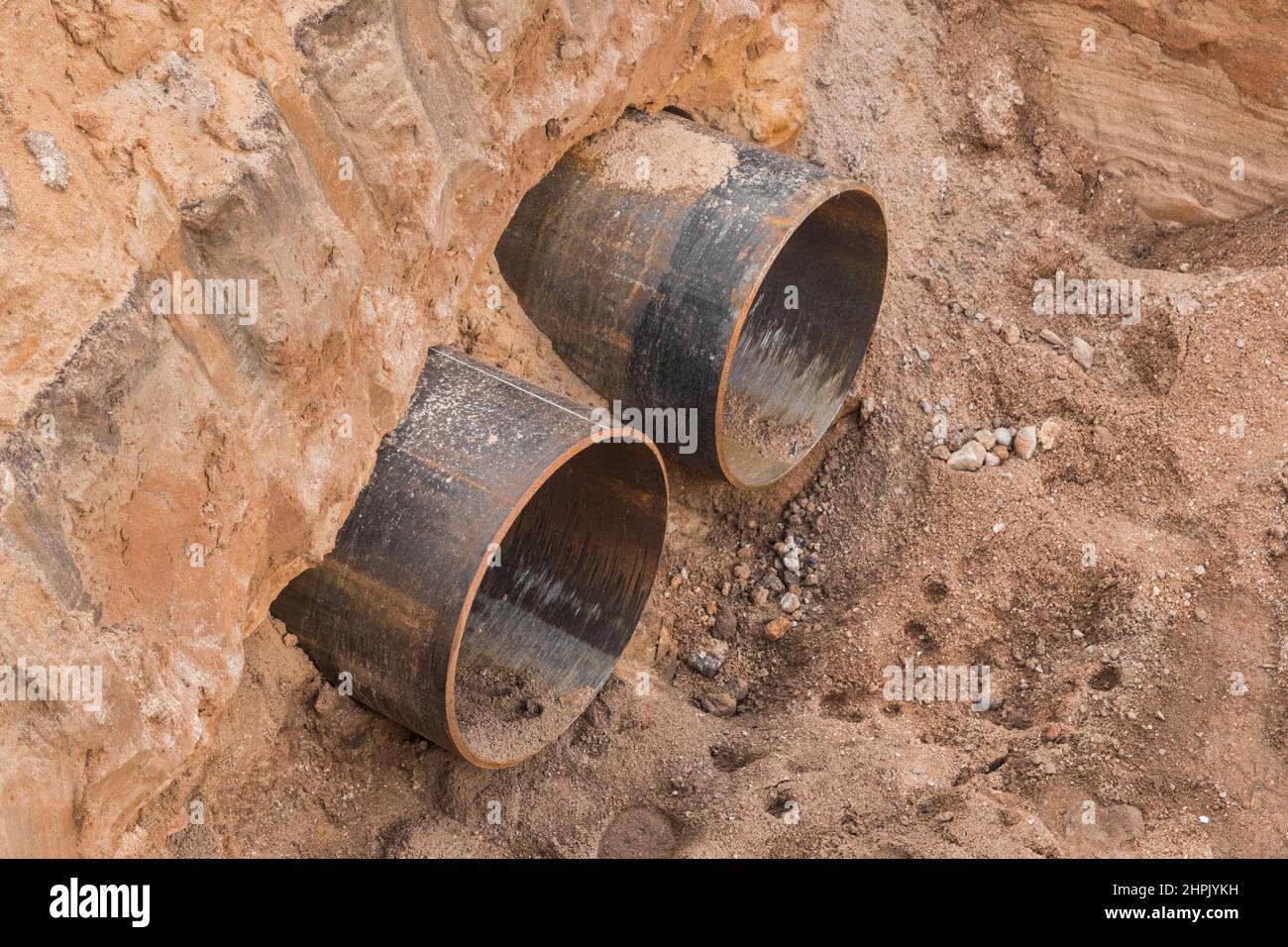 Riparazione del tubo tondo in acciaio della tubazione la rete riscaldante nel settore industriale dei lavori di costruzione a terra. Foto Stock