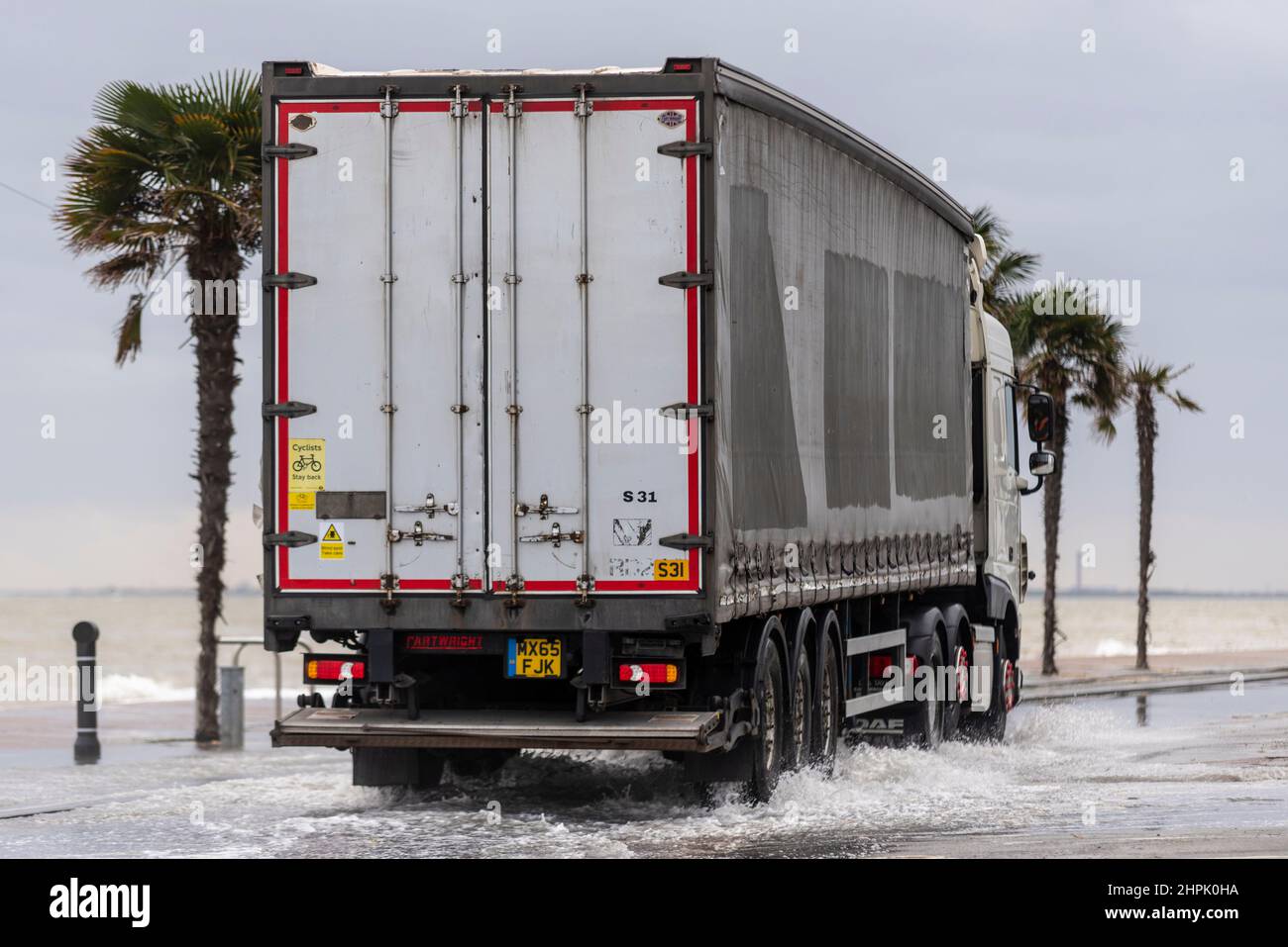 Camion che guida attraverso le inondazioni di acqua salata durante un'alta marea combinata con Storm Franklin a Southend on Sea, Essex, Regno Unito. Trasporto del carico Foto Stock