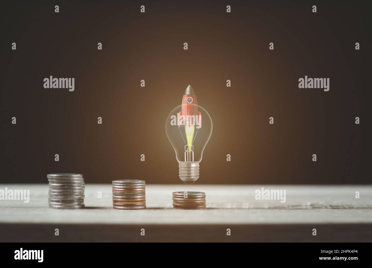 Razzo a lampadina con scala a moneta per piani finanziari o idee di business. Foto Stock