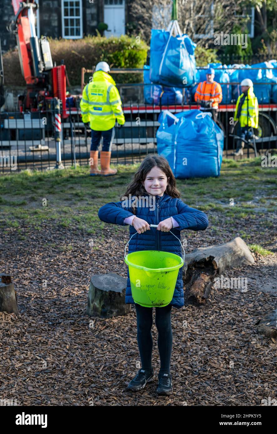 Trinity Primary School, Edimburgo, Scozia, Regno Unito, 22 febbraio 2022. Topsoil Botanico per le scuole: Scavo durante il Royal Botanic Garden Biomes Project risulta in un'eccedenza di 50 tonnellate di topsoil che è dato alle scuole, allotments & organizzazioni della comunità dalla società di costruzione Balfour Beatty. Una consegna di 5 tonnellate avviene presso la Trinity Primary School per trasportare il suolo o la terra per riempire piantatrici nel giardino della scuola per gli allievi per coltivare le verdure. Gli allievi primari 4 usano contenitori di tutte le forme e dimensioni per spostare la terra per riempire le piantatrici; lavoro di squadra è richiesto Foto Stock