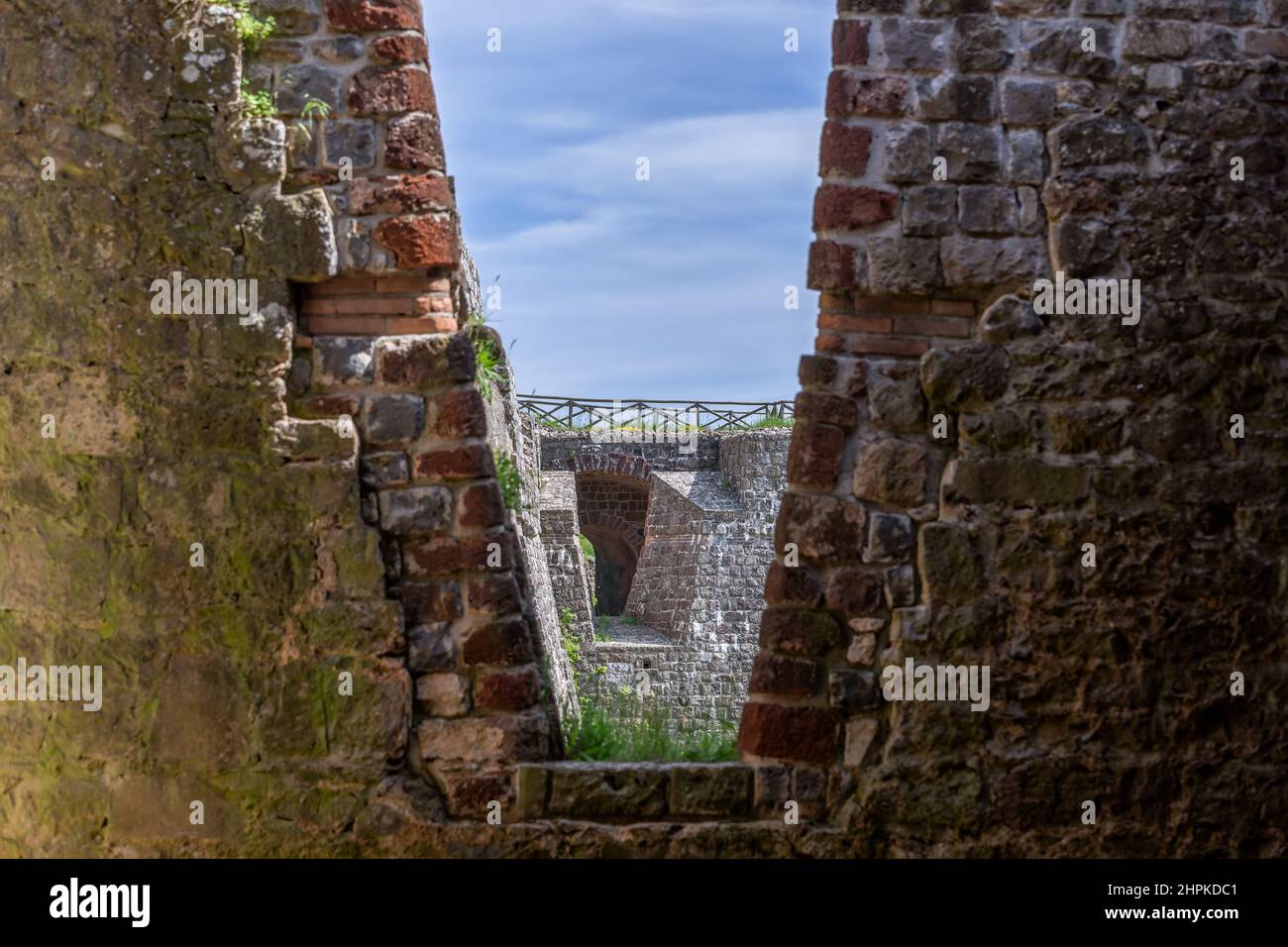 La trama di antichi mattoni con apertura a V nella torre Rocca di Radicofani. Toscana, Italia Foto Stock