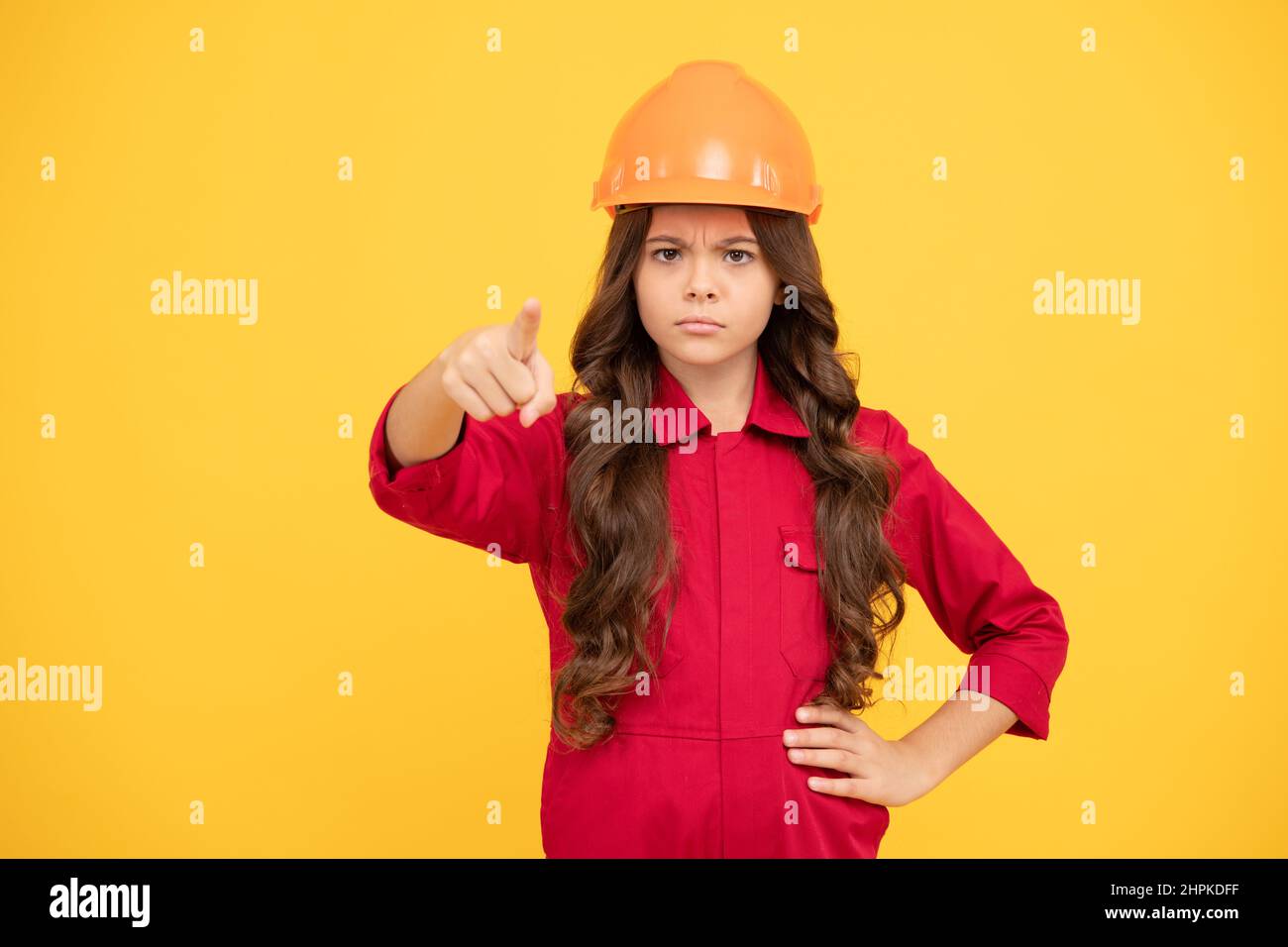 teen girl punta dito. bambino in casco protettivo per edilizia. protezione e sicurezza. Foto Stock