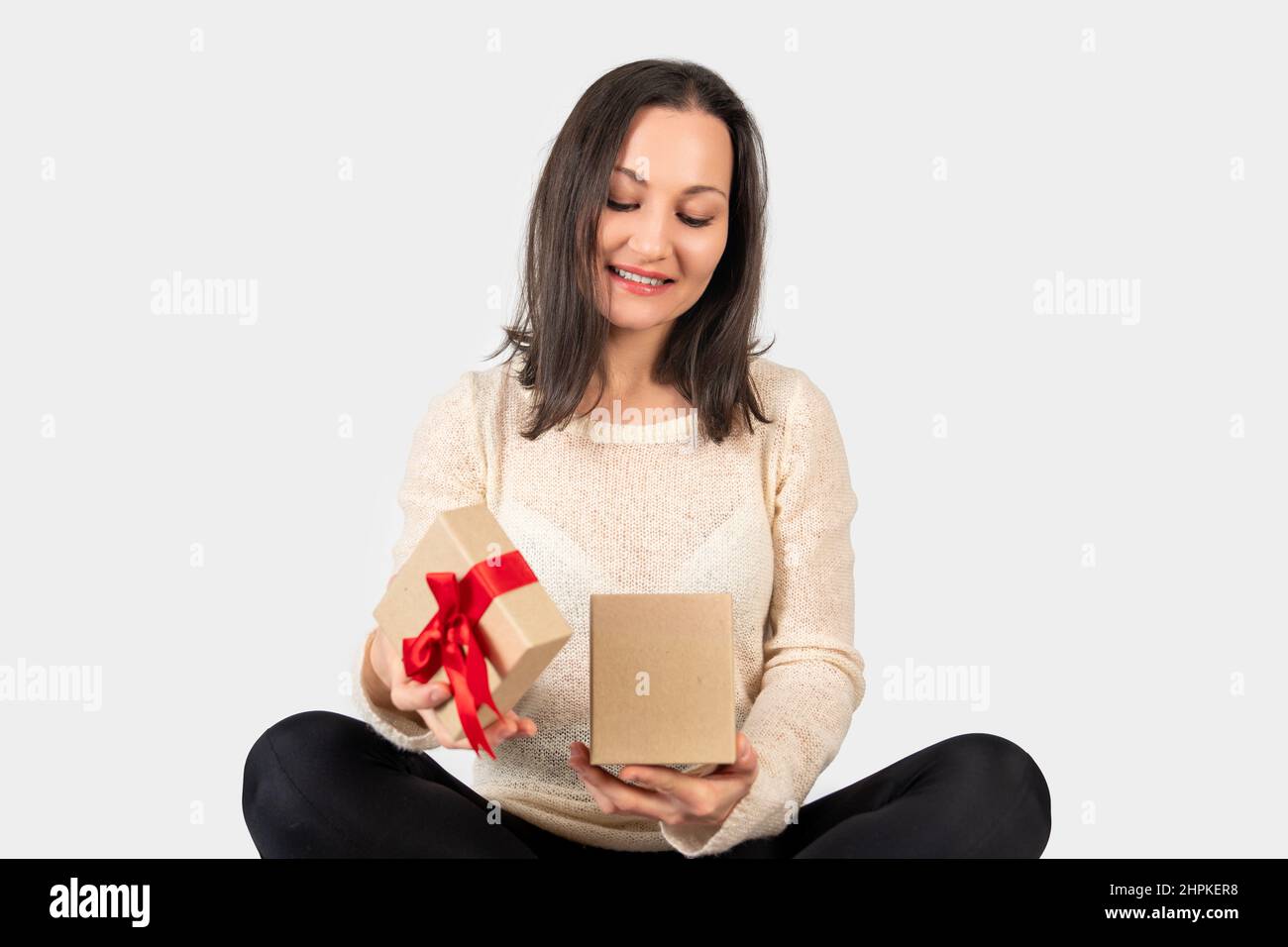 La giovane donna ha ricevuto una confezione regalo per un giorno speciale e la ha aperta con un volto felice. Foto di alta qualità Foto Stock