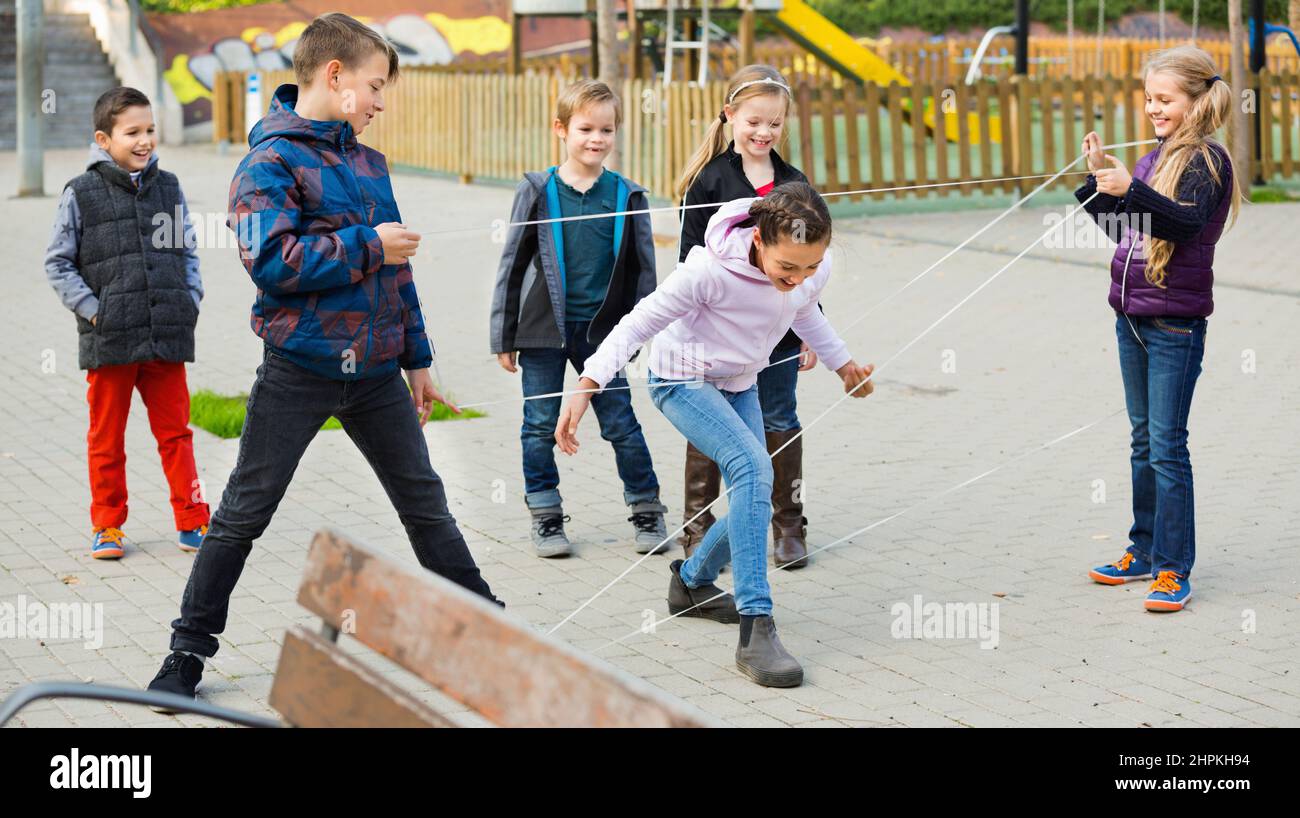 Giochi per bambini. La ragazza passa attraverso la corda aggrovigliata Foto Stock