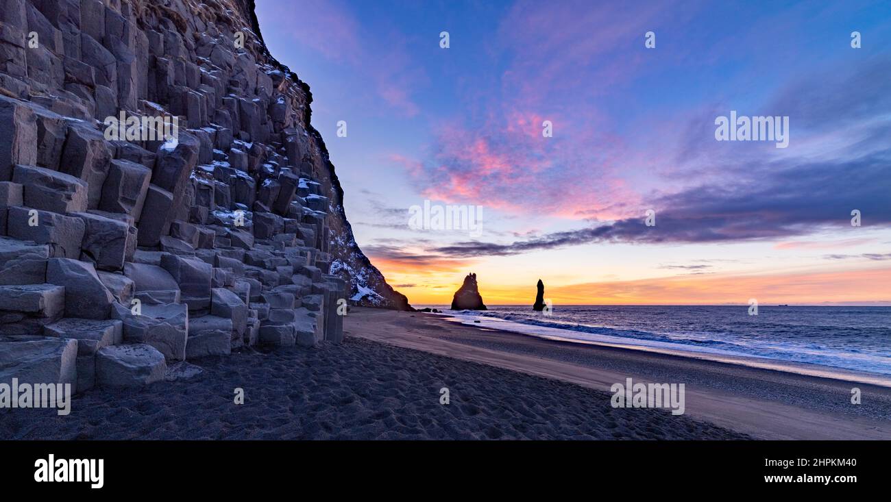 Spettacolare alba sulla spiaggia di sabbia nera di Reynisfjara e rocce basaltiche, vicino al villaggio di Vík i Myrdal, Islanda sud-orientale Foto Stock