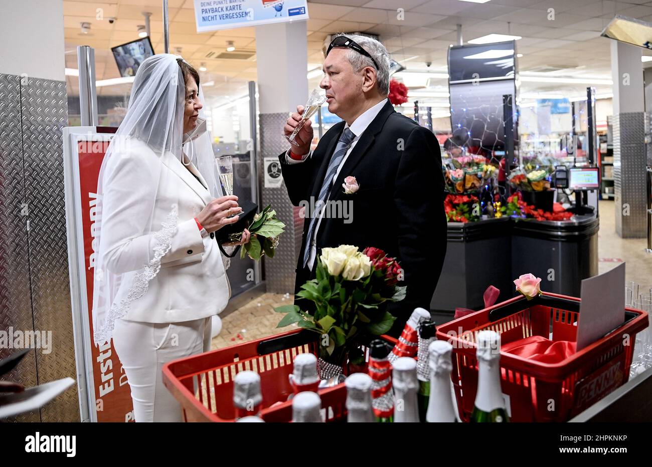 Berlino, Germania. 22nd Feb 2022. Leo e Carola brinda al check-out dopo la cerimonia di nozze in un ramo della catena di supermercati Penny nel quartiere Wedding di Berlino. In occasione dell'ambita data di matrimonio del 22.02.2022, le coppie che avevano fatto la loro mente con breve preavviso potrebbero simbolicamente dire 'lo faccio' alla promozione 'Las Wedding'. Tuttavia, il matrimonio non è valido. Credit: Brittta Pedersen/dpa-Zentralbild/dpa/Alamy Live News Foto Stock