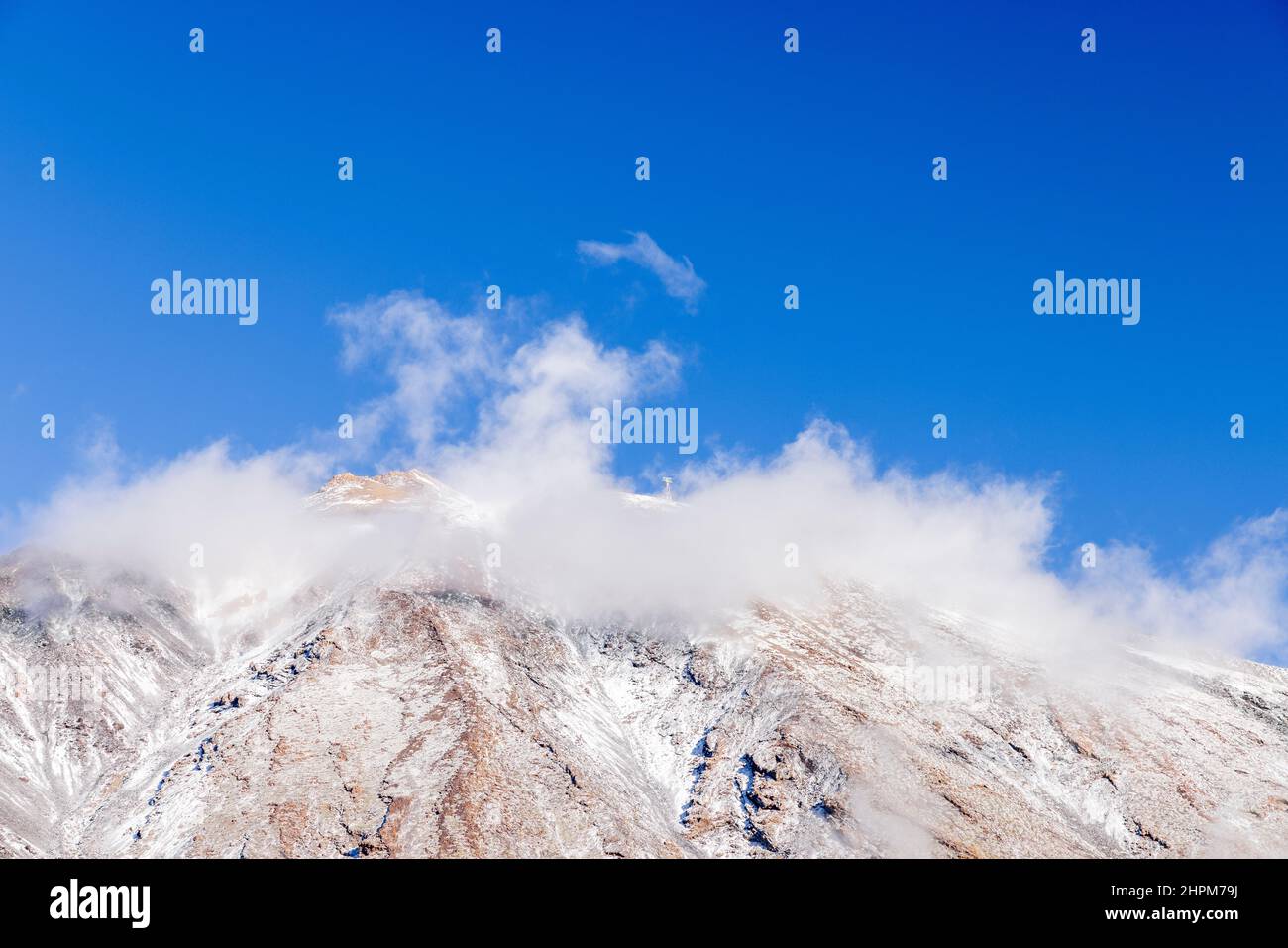 Sole sulle piste innevate del Monte Teide e nuvola leggera contro un cielo blu, nel Parco Nazionale Las Canadas del Teide, Tenerife, Canary IS Foto Stock