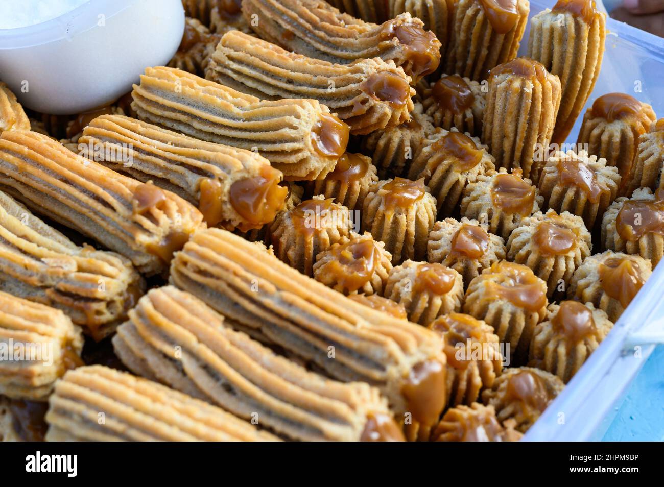 Churros peruviani impilati su una scatola di plastica Foto Stock