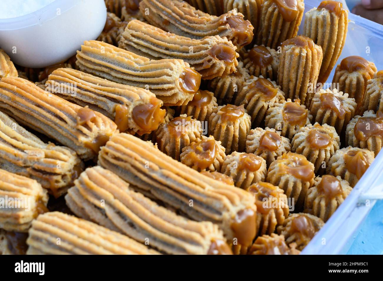 Churros peruviani impilati su una scatola di plastica Foto Stock