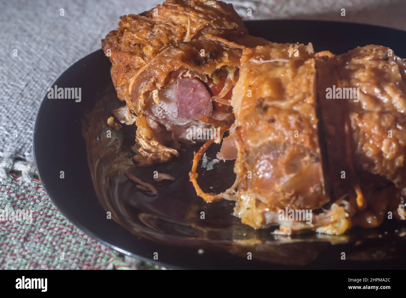 involtini di pollo ripieni arrostiti su un piatto nero, spazio di copia a sinistra. Foto Stock