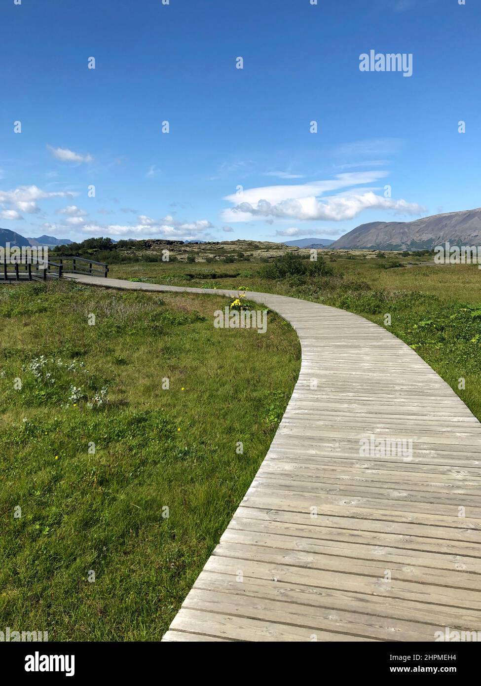 Un sentiero di legno che conduce attraverso Thingvellir in Islanda in una giornata di sole Foto Stock