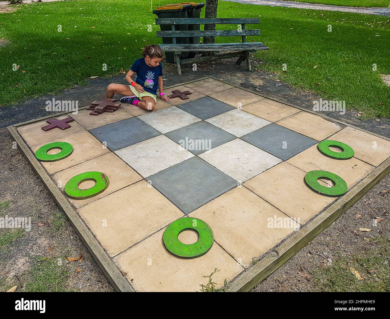 Una ragazza gioca Tic TAC Toe (Noughts and Crosses) su un grande asse presso la fattoria e parco divertimenti di Amazement, Yarramalong, Central Coast, NSW, Australia Foto Stock