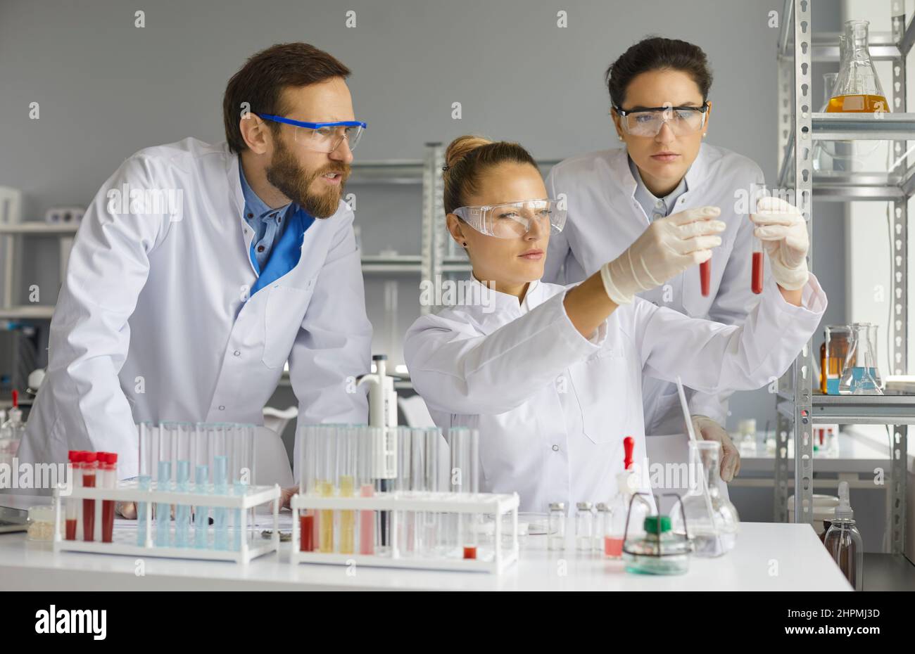 Il team di scienziati esamina attentamente e confronta i campioni di sangue nelle provette di laboratorio. Foto Stock