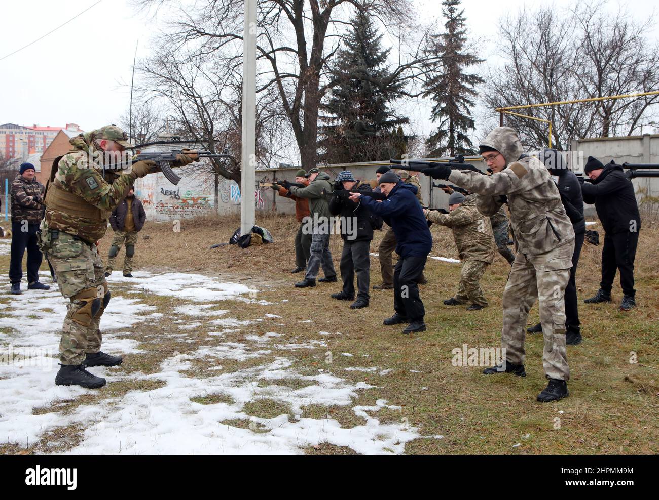 KHARKIV, UCRAINA - 19 FEBBRAIO 2022 - Un uomo in una divisa mimetizzata insegna agli uomini come maneggiare le armi da fuoco durante la trivella di difesa territoriale per civile Foto Stock
