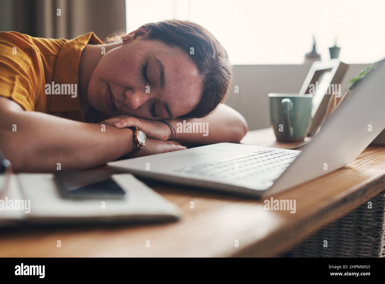 Mi sono perso la rampa sul mio letto. Scatto di una giovane donna che dorme alla sua scrivania mentre lavora da casa. Foto Stock