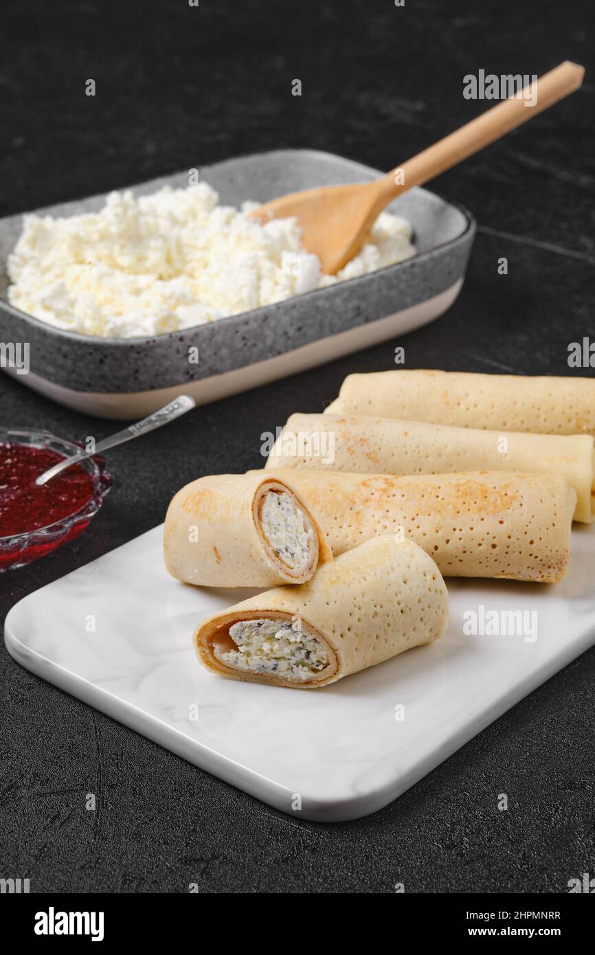 Pancake fatti in casa ripieni di formaggio casereccio su piatto di servizio in marmo Foto Stock