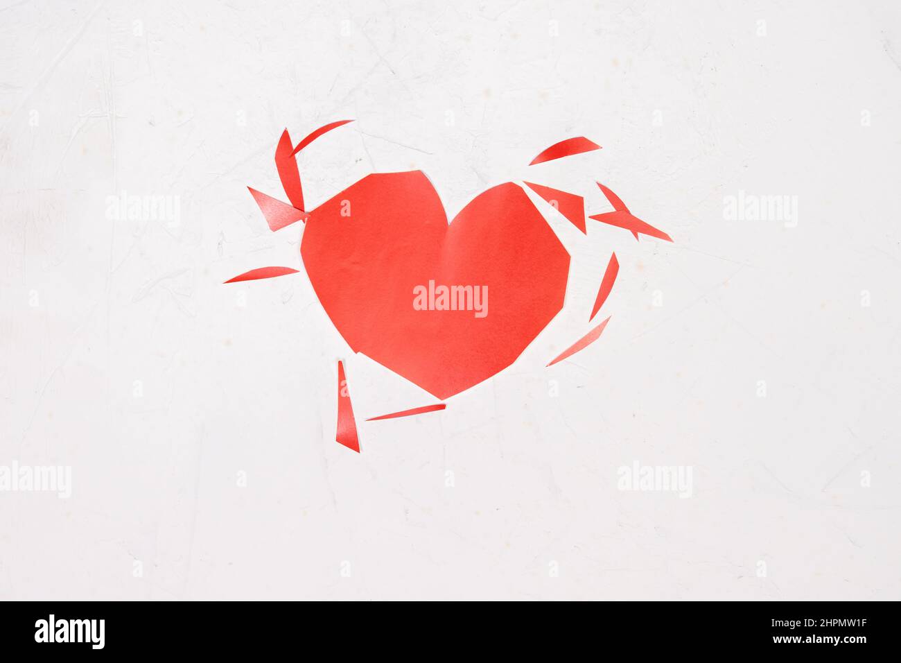 cuore strappato su sfondo bianco. Truffa, delusione nell'amore, concetto di amore non riacclamato. Foto Stock