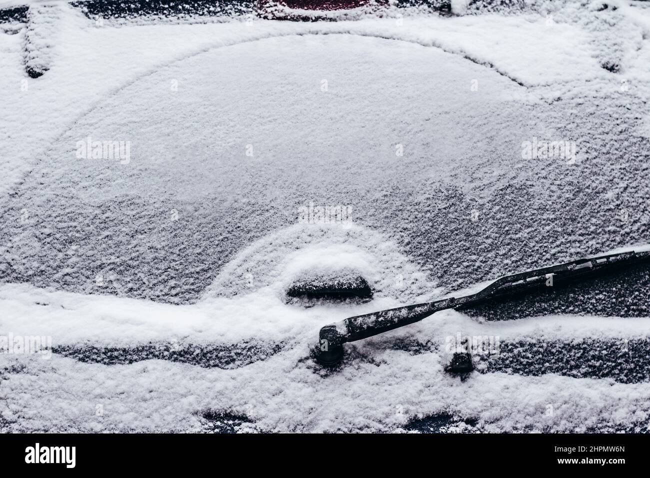 Foto del finestrino posteriore con spazzole tergicristalli coperte di neve Foto Stock