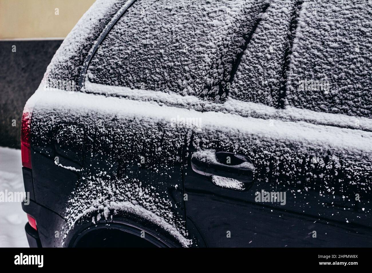 Foto delle portiere e dei finestrini delle auto di colore nero ricoperti di neve. Foto Stock