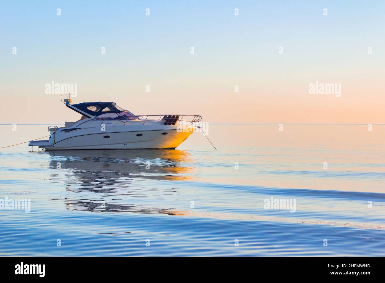 Foto di barca a motore bianca che deriva in mare aperto tramonto sera. Foto Stock