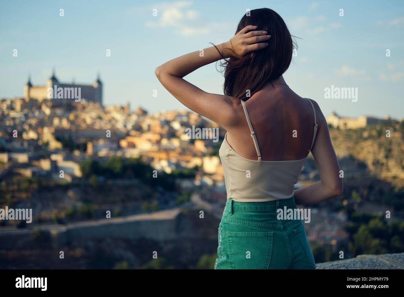 Vista posteriore, giovane donna godere di Toledo vista paesaggio urbano, dalla piattaforma di osservazione. Donna turistica che guarda famosi punti di riferimento, paesaggio della città. Diraspatura di traslazione Foto Stock
