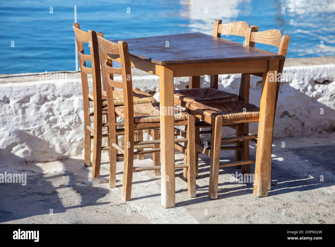 Taverna esterna sul mare, pesce e frutti di mare ristorante tavolo vuoto e sedia, giorno di sole. Grecia, destinazione estiva Foto Stock