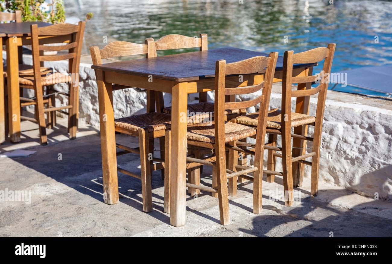 Taverna esterna sul mare, pesce e frutti di mare ristorante tavolo vuoto e sedia, giorno di sole. Grecia, destinazione estiva Foto Stock