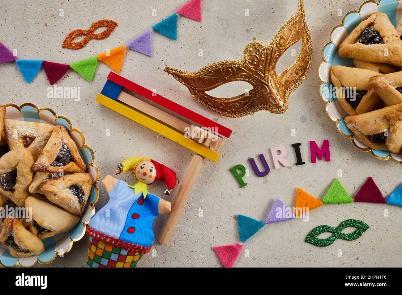 Vacanza ebraica Purim sfondo con amantaschen o hamans orecchie biscotti, maschera di carnevale e noisemaker Foto Stock