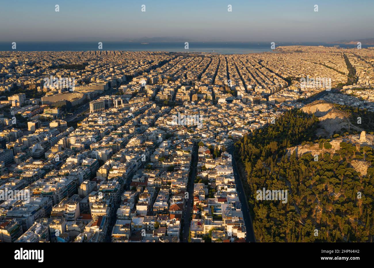 Alba, vista dall'alto della famosa Atene, strade rettangolari e una griglia di edifici, quartieri diretti verso il mare, montagne all'orizzonte, Gree Foto Stock