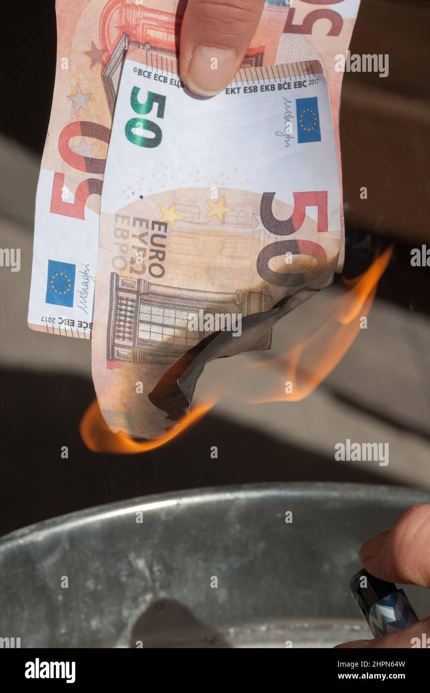 le mani della donna bruciano 50 euro bollette con un accendino Foto Stock