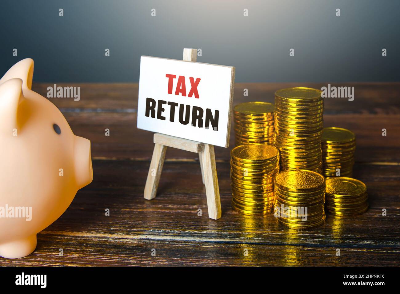 Dichiarazione fiscale. Piggy banca e monete. Richiedere il rimborso per il pagamento in eccesso di tasse. Benefici e programmi educativi. Rifornimento e compensazione su s. Foto Stock