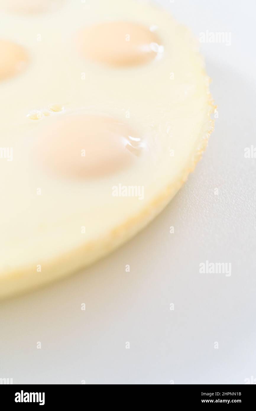 Tagliare le uova sode a forma di pane su un tagliere bianco. Foto Stock