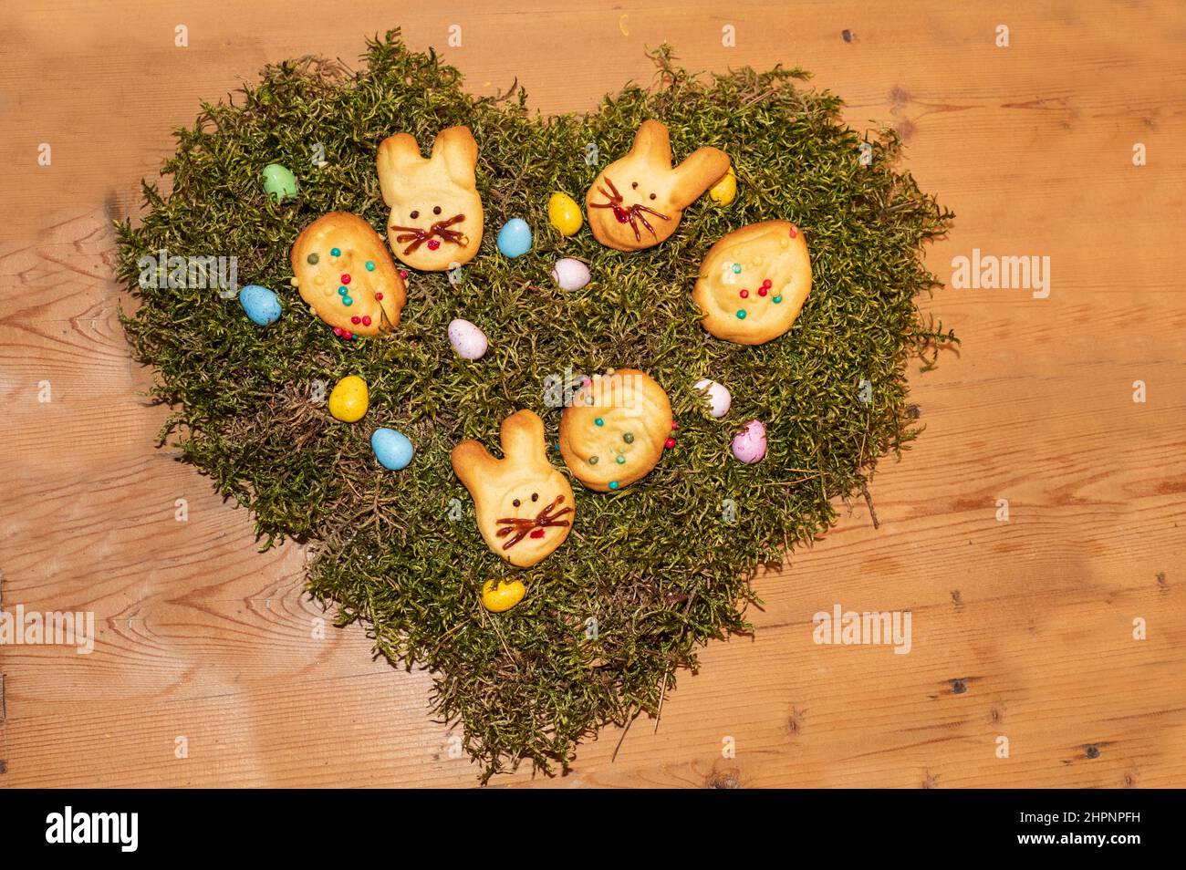 Hasen und Eier Kekse auf einem Herz aus Moos zu Ostern Foto Stock