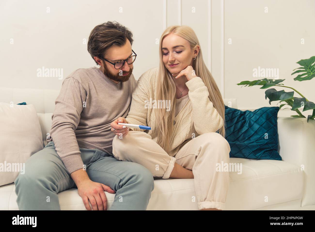 l'uomo d'affari caucasico scopre che il suo fidanzato a capelli lunghi è incinta guardando i risultati di un test di gravidanza. Foto di alta qualità Foto Stock