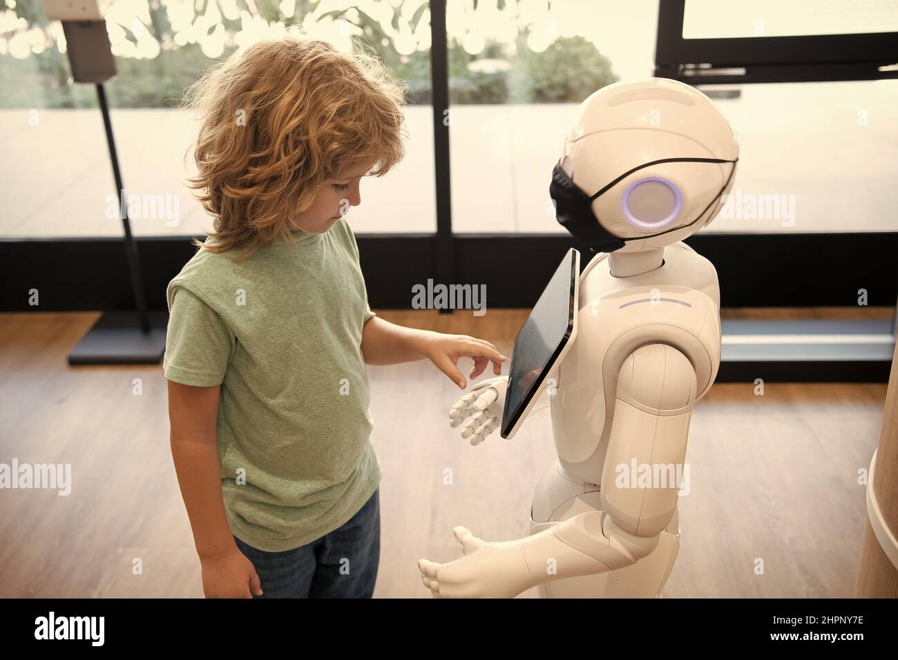 il ragazzo intelligente comunica con la tecnologia robot assistant per l'istruzione moderna e l'automazione. Foto Stock