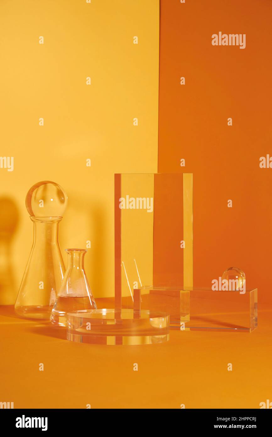 Podio in vetro e scena floreale minimale con nervature su sfondo giallo. Stand per mostrare il prodotto cosmetico. Vetrina su piedistallo moderno in vetro Foto Stock