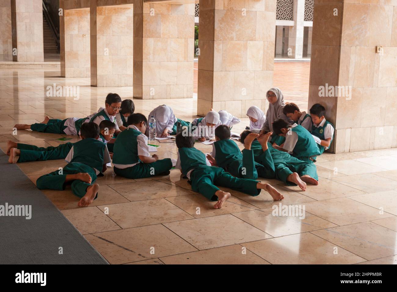 Giovani studenti che studiano nella moschea Istiqlal di Giacarta. Foto Stock