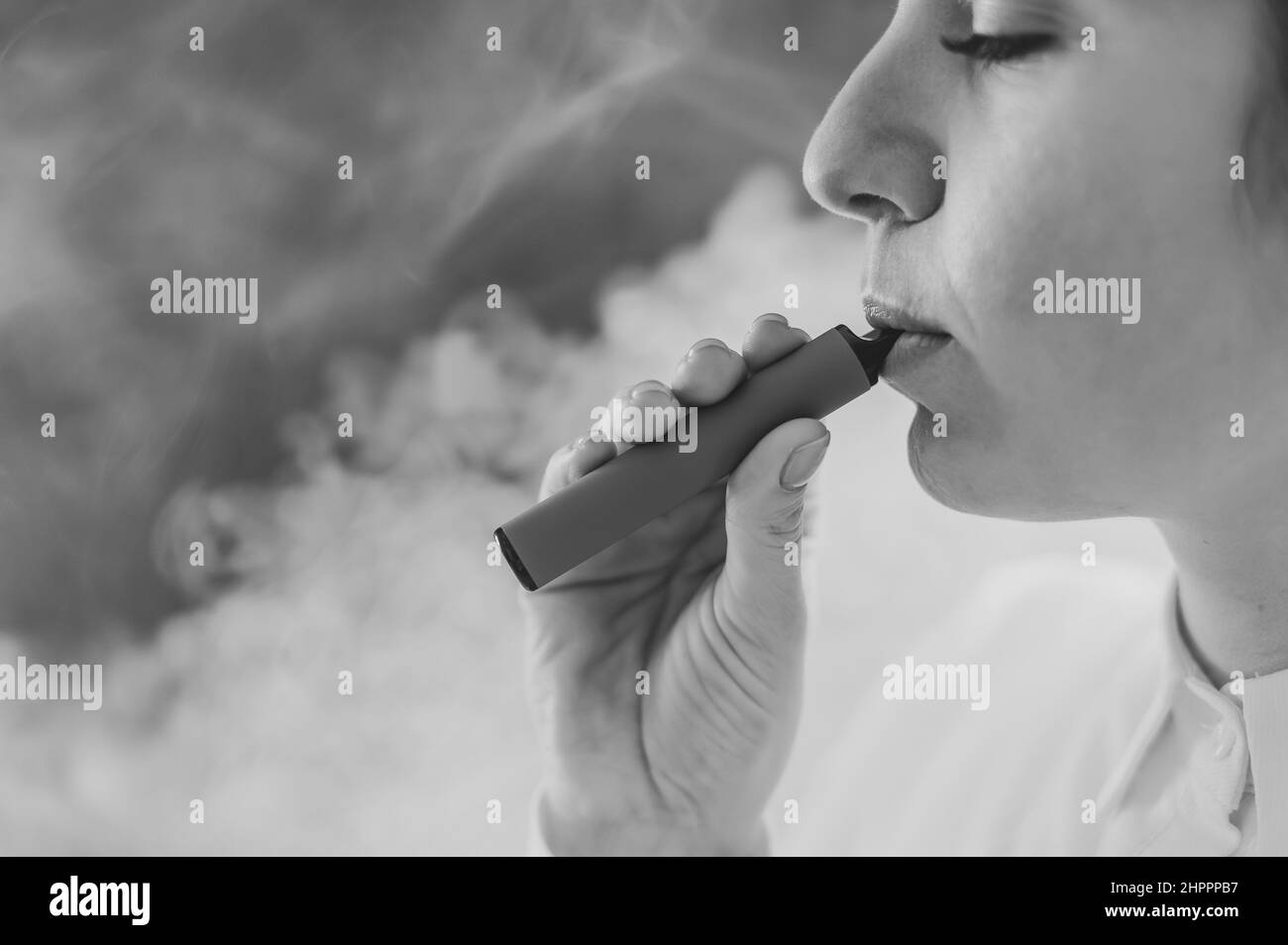 Il medico tiene uno smartphone con uno schermo nero su sfondo bianco. Foto in bianco e nero. Foto Stock