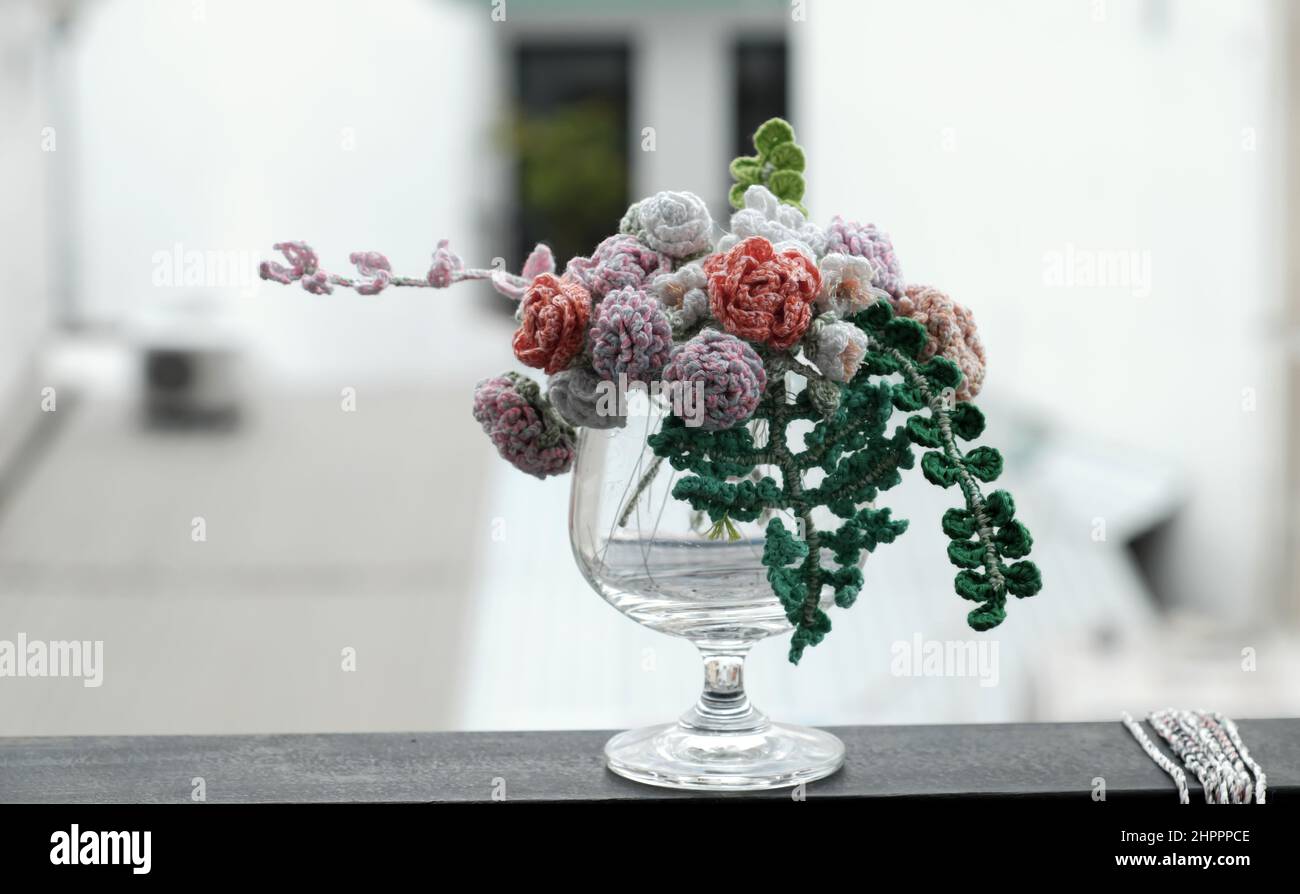 Sorprendente crochet vaso fiore fatto a mano da filato con mini rosa e foglia verde per la casa decorazione, l'arte può fare dono Foto Stock