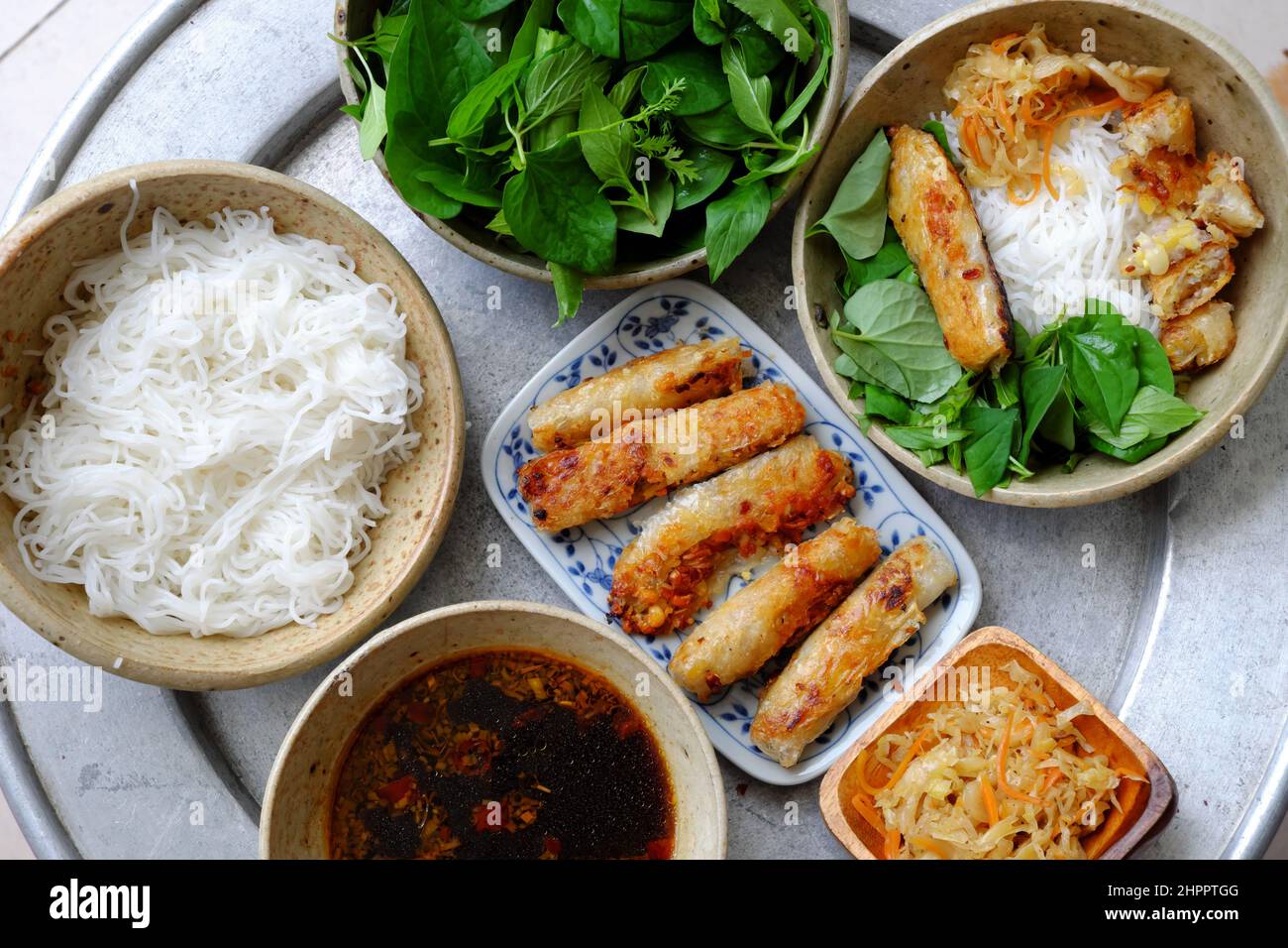 Vassoio con vista dall'alto di cibo vietnamita per il fine settimana con pasto di famiglia, spaghetti di riso fritti con lattuga e foglia di basilico e salsa di soia, piatto di vegano g Foto Stock