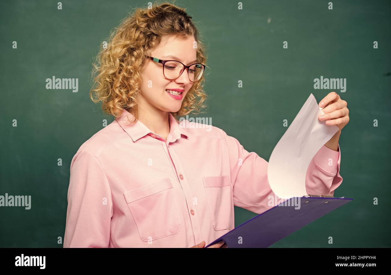 Leggere l'impressing RESUME. Il tutor controlla le esercitazioni. Saggio preventivo dei richiedenti. Progetto scolastico. L'insegnante di letteratura legge la composizione. Donna signora intelligente Foto Stock